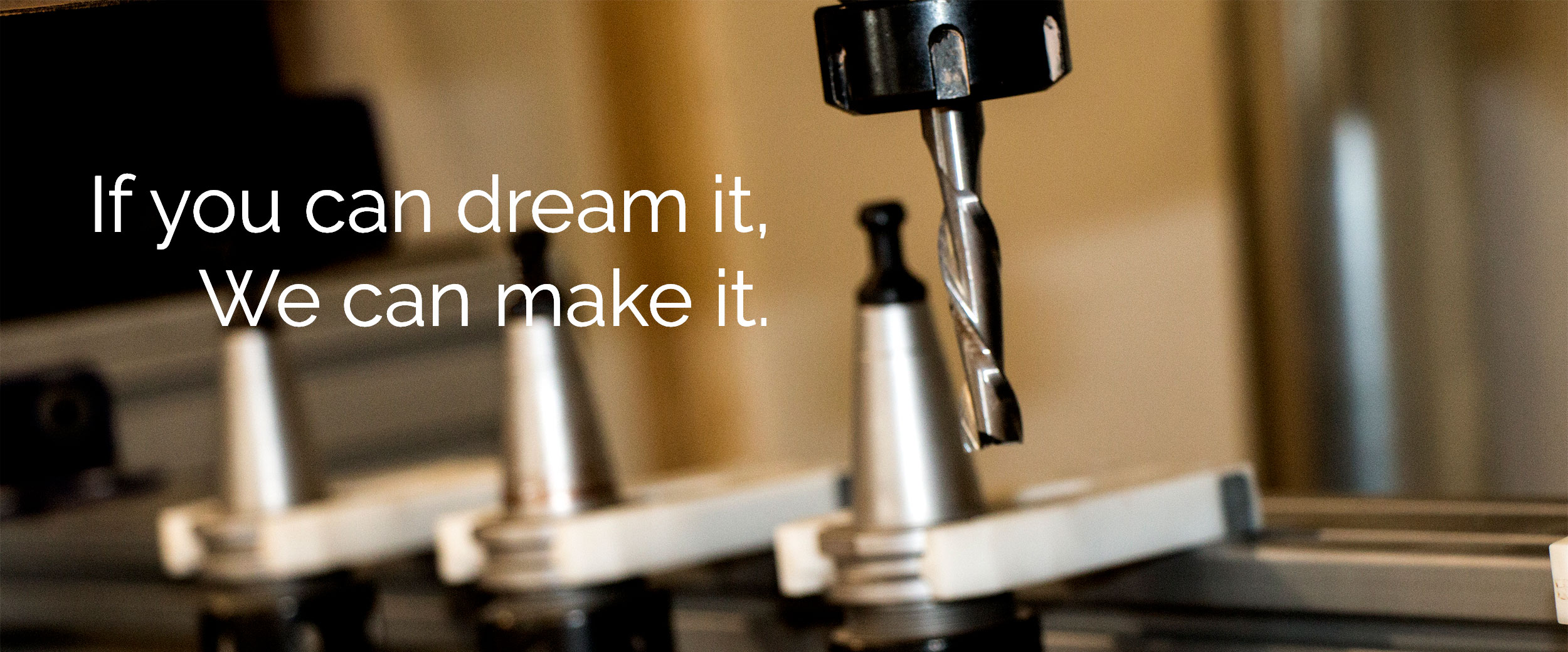 close up photo of drill bit on 3 axis cnc machine with the words "If you can dream it, we can make it." Written over it.