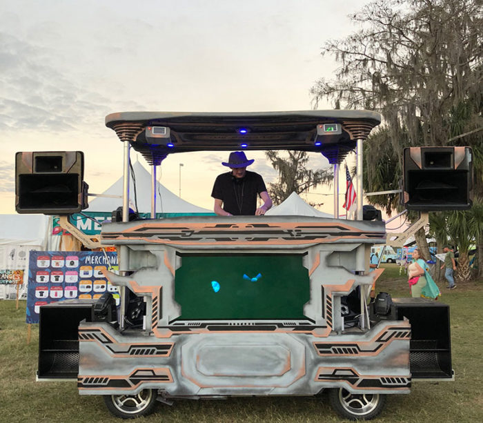 man playing music on a custom designed and fabricated golf cart.