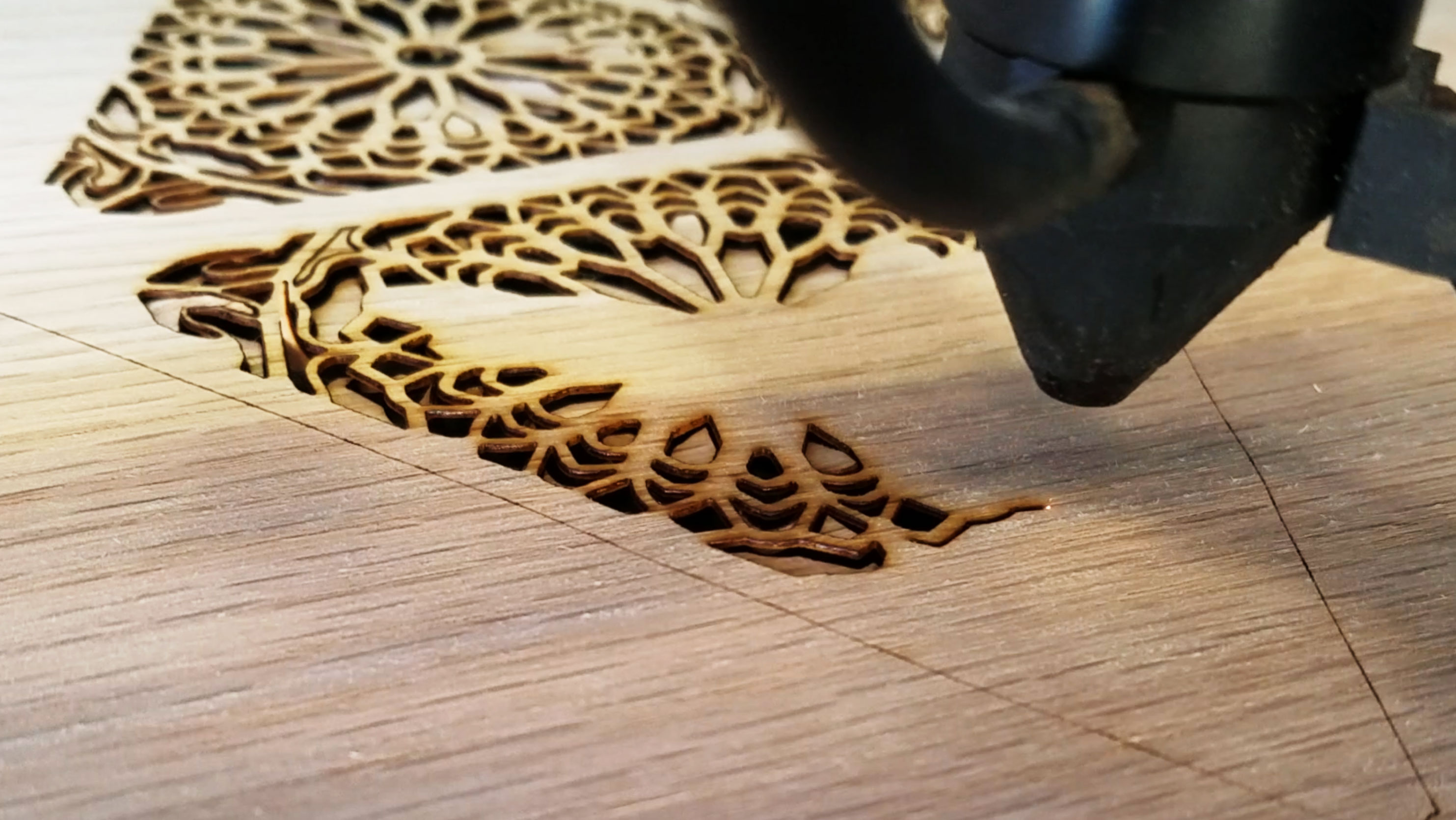 laser machine cutting shapes into wood.