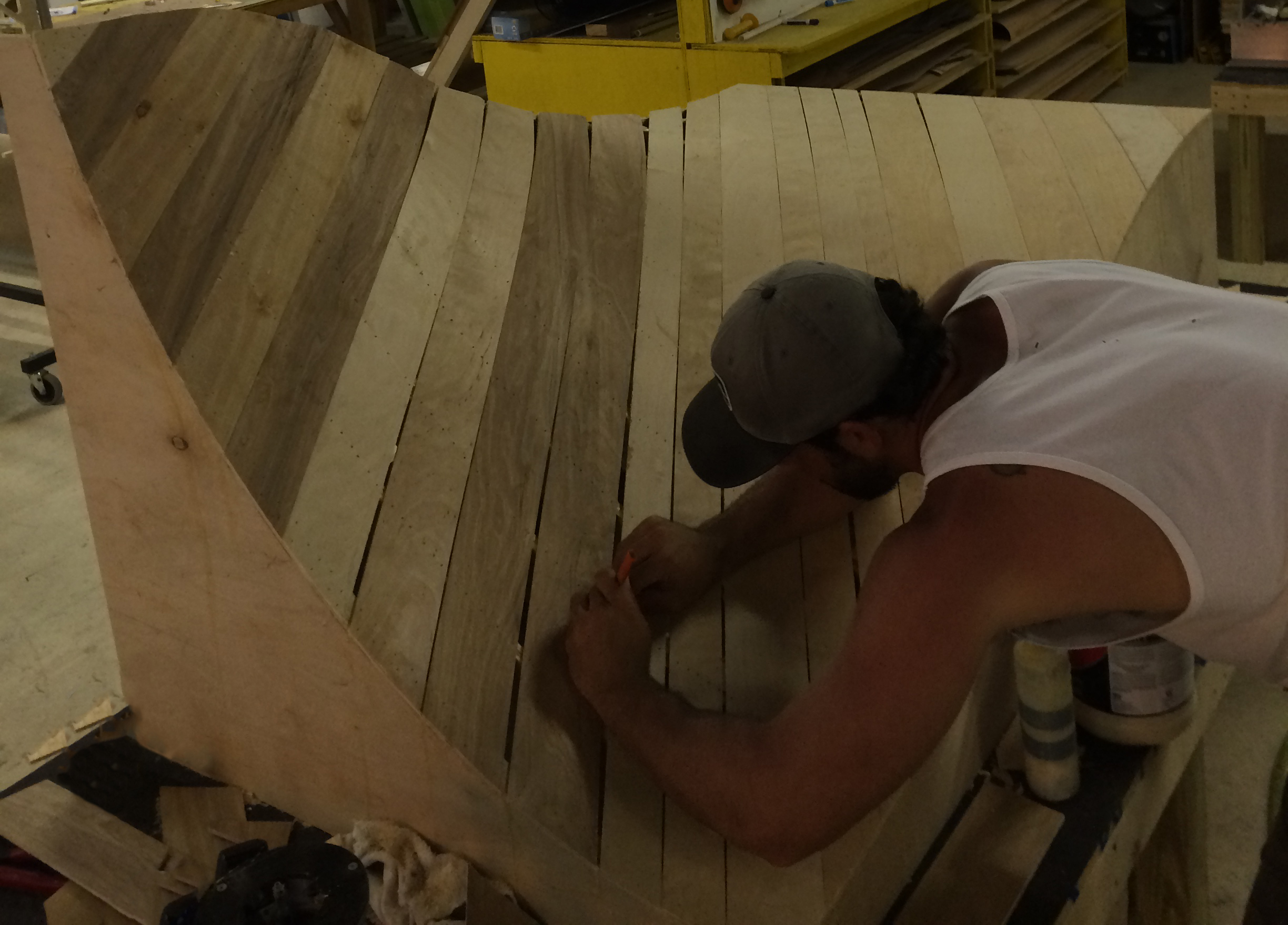 man building a portion of a skating pump track made out of wood