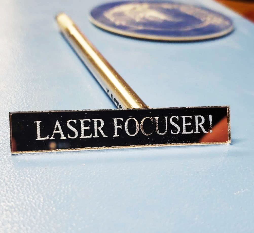 "Laser focuser" words etched into small mirror.