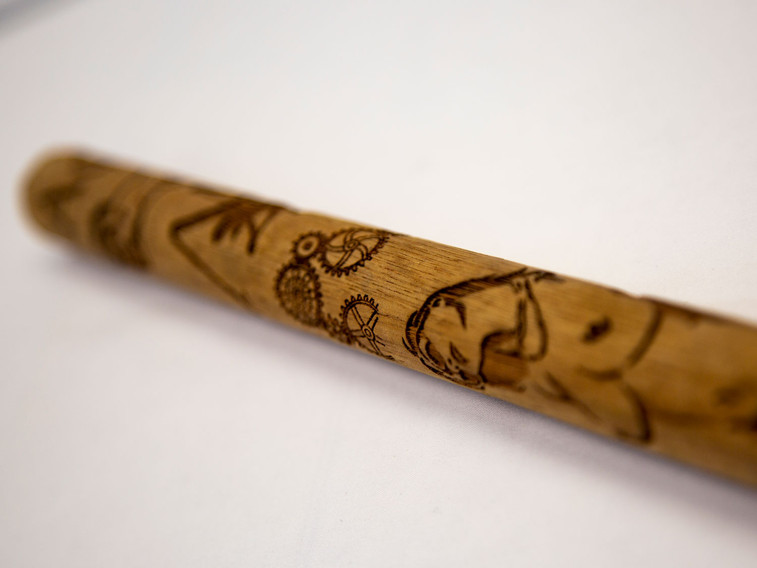 wooden stick with different pictures lasered onto it.