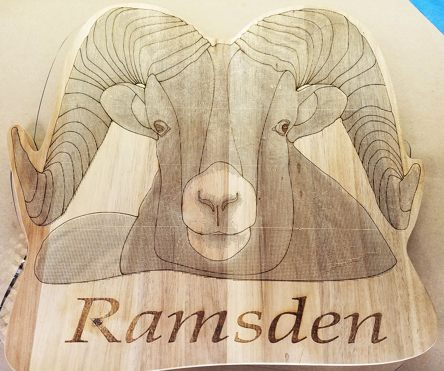 lasered image of a Ram's head on wood.