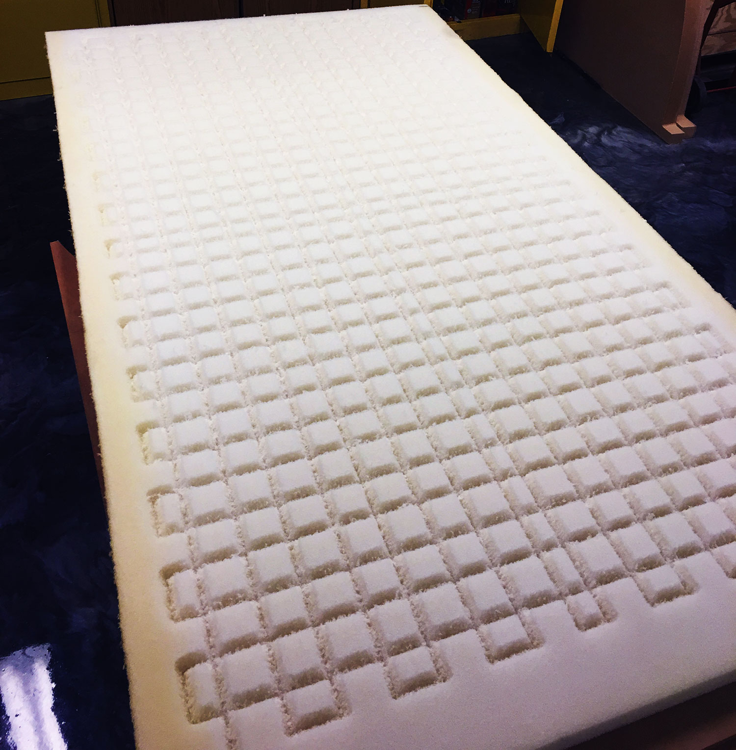 styrofoam piece with cnc cut squares in it.