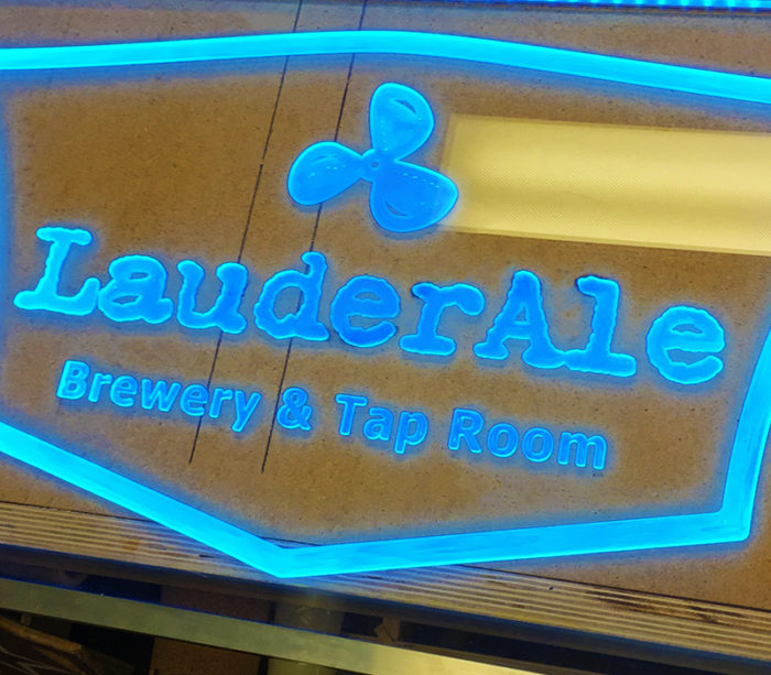 clear sign lit up with blue LED lights for local business.