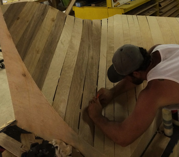 man building a portion of a skating pump track made out of wood